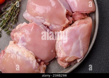 Filets de cuisse de poulet frais crus avec sel, épices et herbes Banque D'Images