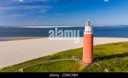 Texel Lighthouse, Une perspective unique de sous le niveau de la mer regardant vers le haut un phare debout sur une plage de sable, aga Banque D'Images