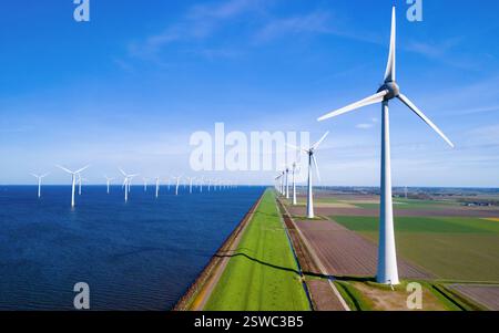 Un paysage serein où une rangée d'éoliennes se dresse à côté d'un plan d'eau tranquille dans les pays-Bas Flevoland pendant Banque D'Images