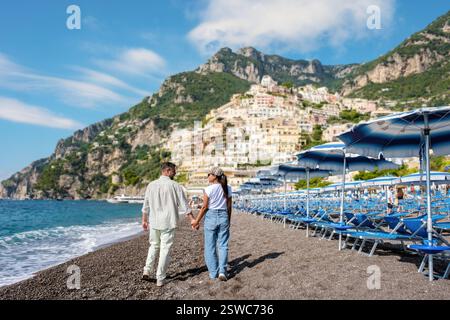 Flâner main dans la main le long de la plage de galets de Positano, Italie Banque D'Images