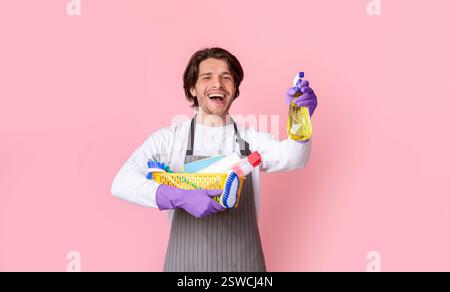 Portrait de l'homme excité avec seau de fournitures de nettoyage dans les mains Banque D'Images
