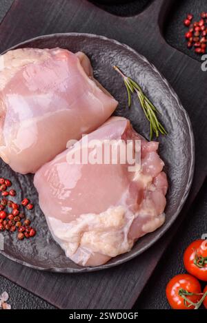Filets de cuisse de poulet frais crus avec sel, épices et herbes Banque D'Images