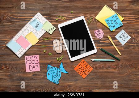 Tablette, clavier d'ordinateur, souris de carton et notes adhésives. Farce du jour des fous d'avril Banque D'Images