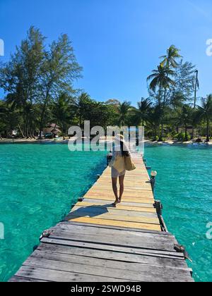 Promenez-vous le long de la pittoresque jetée de Koh Kood entourée d'eaux turquoises et de palmiers Banque D'Images