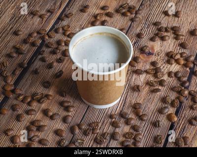 Le café dans une tasse en papier est sur la table brune. Banque D'Images
