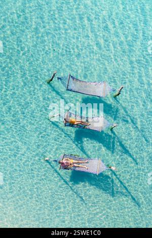Détente sur des hamacs au-dessus des eaux cristallines à Koh Kood, Thaïlande Banque D'Images