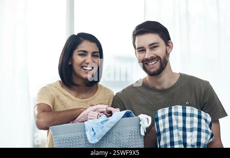 Lessive, pli et portrait de couple avec des vêtements pour le nettoyage, la corvée et l'hygiène à la maison. Mariage, relation et homme et femme heureux avec lavage Banque D'Images