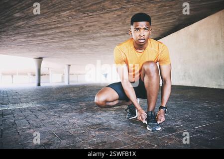Chaussures, coureur et lacets avec homme noir en ville pour le défi d'entraînement, l'exercice et la course. Départ, pratique du marathon et santé avec personne dans le stationnement Banque D'Images