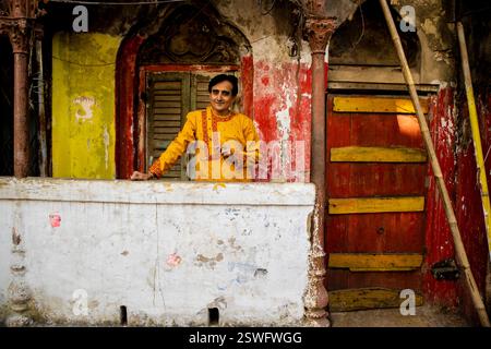 Un indien portant un dhoti rouge bengali traditionnel indien et kurta orange posant en plein air dans les rues de kolkata Banque D'Images