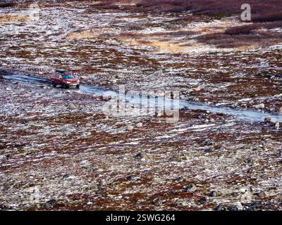 Route arctique glacée glissante à travers la toundra. Dépôt de touristes en voiture. Banque D'Images