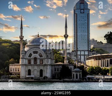 Une vue panoramique d'une mosquée historique avec deux minarets à côté d'un gratte-ciel moderne à Istanbul, Turquie, pendant le coucher du soleil. Le ciel est rempli de nuages et Banque D'Images