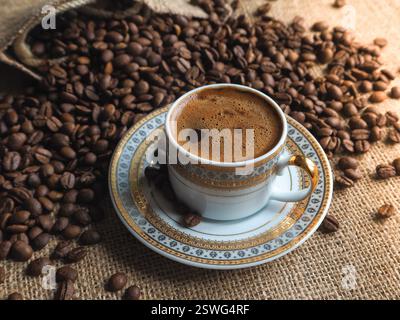 Tasse à café expresso avec grains sur fond de toile de fond. Banque D'Images
