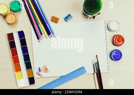 Espace de travail créatif avec fournitures artistiques et toile vierge prête pour l'expression artistique dans un cadre domestique Banque D'Images