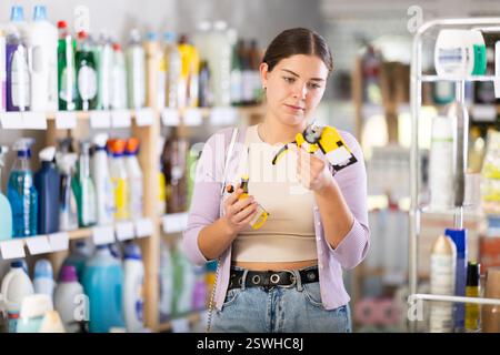 Jeune femme choisissant des outils dans un grand magasin de ménage Banque D'Images