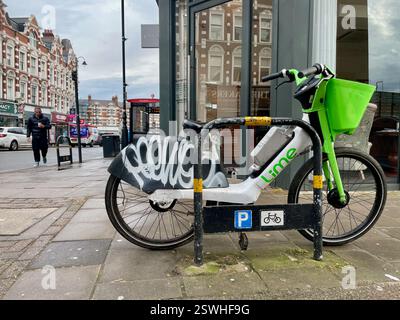 un vélo à louer à la chaux couvert de graffiti garé sur un trottoir à muswell hill au nord de londres angleterre Banque D'Images