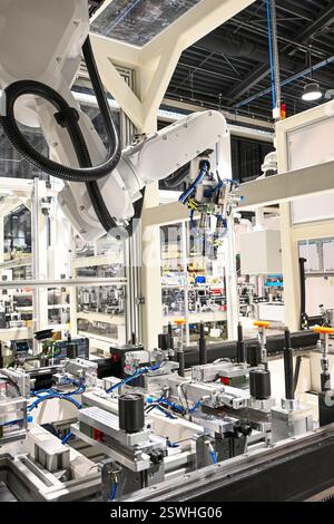 Bras robotique moderne effectuant des tâches sur une ligne de production automatisée dans une usine high-tech. Banque D'Images