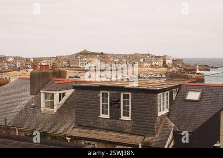 Vue sur les toits et les cheminées jusqu'à Harbour Beach, Smeaton's Pier, New Pier et St Nicholas Chapel à St Ives, Cornwall, Angleterre Banque D'Images