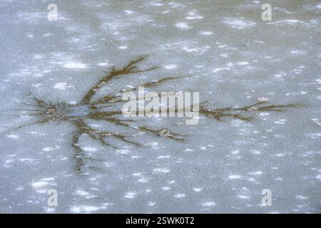 Image abstraite d'une fissure dans la couverture de glace d'un lac boueux Banque D'Images
