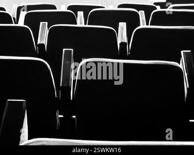 Sièges éclairés. La lueur abstraite de la magie de la nuit cinématographique. Noir et blanc, Banque D'Images