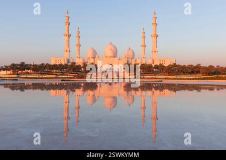 La Grande Mosquée Sheikh Zayed (2007) avec réflexion de l'eau à Abu Dhabi, Emirats Arabes Unis au lever du soleil Banque D'Images