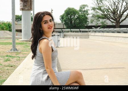 Belle femme brune profitant d'une journée ensoleillée dans un parc Banque D'Images