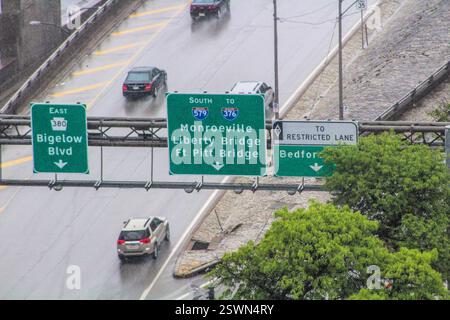 Les panneaux de signalisation les jours de pluie guident les véhicules sur une autoroute très fréquentée à Pittsburgh, en Pennsylvanie. Banque D'Images