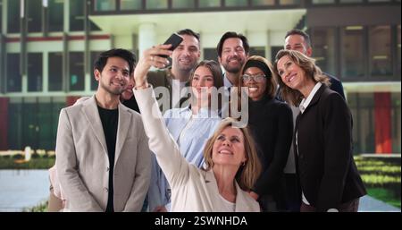 Équipe d'affaires multiraciale souriant ensemble prendre Selfie au travail événement Banque D'Images