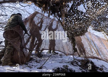 Marioupol, Ukraine. 22 février 2025. Camouflage d'un char T64 par l'équipage de la 56e brigade d'infanterie motorisée séparée de Marioupol en position fermée près du front dans la région de Donetsk. Peu avant le troisième anniversaire de la guerre en Ukraine lors des négociations de cessez-le-feu, le 21 février 2025. Photo. Par Yevhen Titov/ABACAPRESS. COM Credit : Abaca Press/Alamy Live News Banque D'Images