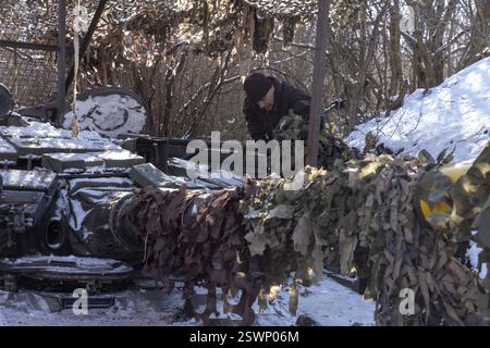 Marioupol, Ukraine. 22 février 2025. Camouflage d'un char T64 par l'équipage de la 56e brigade d'infanterie motorisée séparée de Marioupol en position fermée près du front dans la région de Donetsk. Peu avant le troisième anniversaire de la guerre en Ukraine lors des négociations de cessez-le-feu, le 21 février 2025. Photo. Par Yevhen Titov/ABACAPRESS. COM Credit : Abaca Press/Alamy Live News Banque D'Images