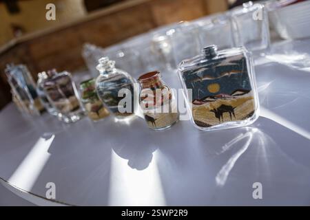 Bouteilles en verre remplies de sable coloré créant de belles représentations artistiques des paysages du désert égyptien, un souvenir traditionnel de marsa al Banque D'Images