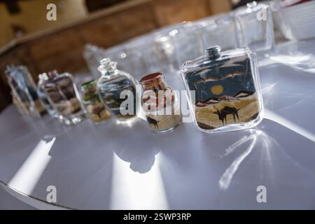 Bouteilles en verre remplies de sable coloré créant de belles représentations artistiques des paysages du désert égyptien, un souvenir traditionnel de marsa al Banque D'Images