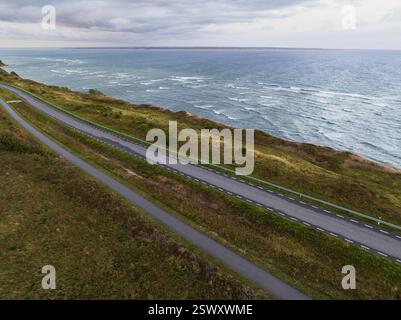 Vue panoramique depuis un drone d'une route longeant une falaise sur la péninsule de Paldiski, Estonie, tôt le matin. Banque D'Images