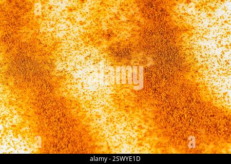 Gros plan de cannelle finement moulue saupoudrée sur un dessert, évoquant l'essence aromatique des pâtisseries traditionnelles, des produits de boulangerie et des boissons épicées Banque D'Images