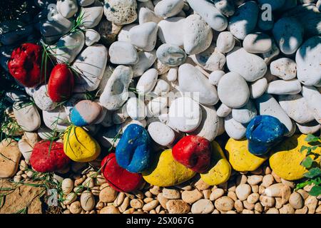 Variété de galets arrondis sur le bord de mer. Texture avec beaucoup de pierres de différentes tailles. Image de nombreuses pierres de couleur, grises, rouges. Banque D'Images