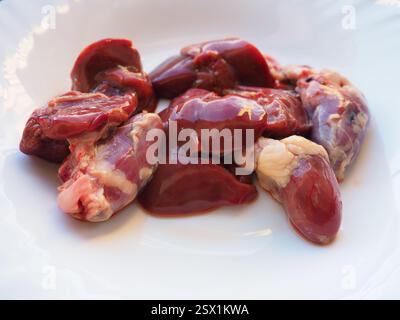 foie de poulet cru, reins et coeur. Entrailles et abats de volaille, préparés pour la cuisson. Un régime riche en fer hémique contre l'anémie. Viande sur blanc Banque D'Images