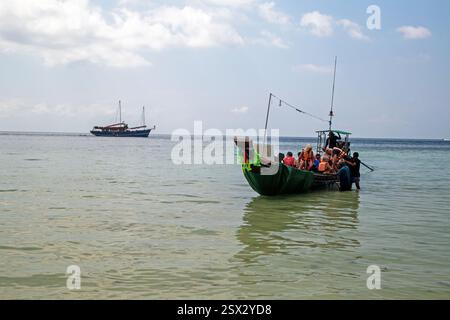 Koh Samui, Thaïlande, le 6 février 2025, les touristes débarquent d'un bateau à longue queue utilisé pour les emmener plus près de la côte depuis le petit bateau sur lequel ils se trouvaient Banque D'Images