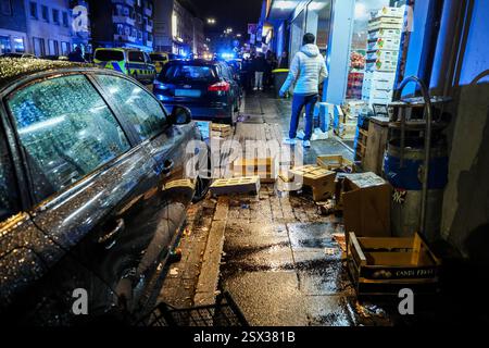 Wuppertal, Allemagne. 22 février 2025. Des caisses en bois détruites se trouvent sur le sol devant un supermarché arabe à Wuppertal-Barmen après une bagarre de masse. Il a été incapable de dire quoi que ce soit au sujet du nombre de personnes impliquées ou des blessures possibles. Crédit : Christoph Reichwein/dpa - ATTENTION : plaques d'immatriculation des véhicules pixelisées pour des raisons légales/dpa/Alamy Live News Banque D'Images
