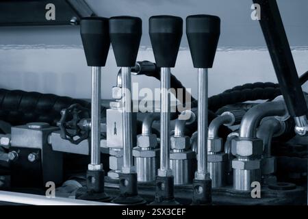 Partie d'une machine industrielle hydraulique, leviers de commande d'une machine hydraulique, système de tuyau hydraulique haute pression industriel connecté à un tuyau en acier Banque D'Images