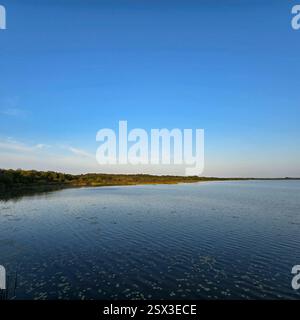 Un coucher de soleil paisible au bord du lac avec un ciel clair et de belles réflexions sur l'eau Steinhuder Meer Banque D'Images