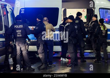 Wuppertal, Allemagne. 22 février 2025. Les policiers se tiennent à côté d'un véhicule de police pendant l'identification des suspects. Une dispute entre deux familles s'était déjà intensifiée, causant des blessures. La police est intervenue. Crédit : Christoph Reichwein/dpa/Alamy Live News Banque D'Images