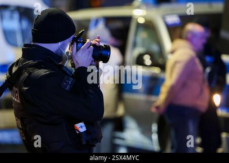 Wuppertal, Allemagne. 22 février 2025. Un policier prend une photo d'un suspect pendant le processus d'identification. Une dispute entre deux familles s'était déjà intensifiée, causant des blessures. La police est intervenue. Crédit : Christoph Reichwein/dpa/Alamy Live News Banque D'Images