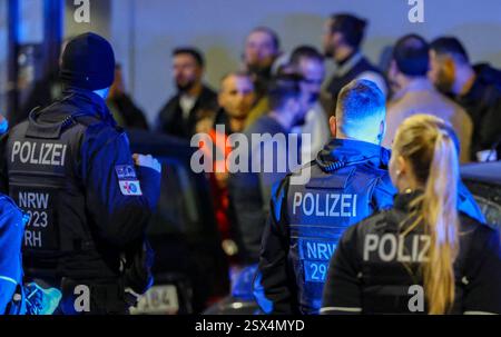 Wuppertal, Allemagne. 22 février 2025. Les hommes se tiennent dans une zone délimitée par la police, d'ici ils sont emmenés pour identification. Une dispute entre deux familles s'était intensifiée et il y avait des blessés. La police est intervenue. Crédit : Christoph Reichwein/dpa/Alamy Live News Banque D'Images
