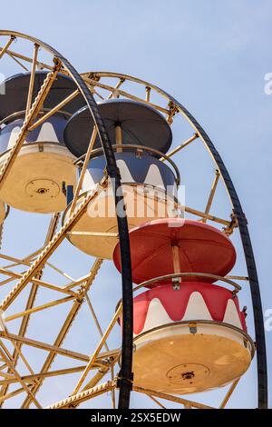 Roues géantes colorées dans l'amusement de parc avec le ciel bleu sur fond Banque D'Images