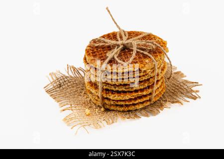 Une pile de gaufres belges fraîchement préparées arrosées de caramel se trouve sur une toile de jute. Ce dessert est parfait pour célébrer la journée nationale du caramel avec esprit Banque D'Images
