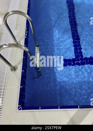 Un gros plan d'une piscine avec une échelle métallique et des tuiles bleues vibrantes, Turquie, Asie Banque D'Images