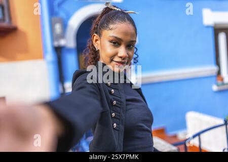 Perspective personnelle d'une femme afro-américaine de beauté prenant selfie à côté de la maison colorée Banque D'Images