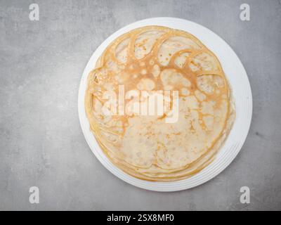 De fines crêpes empilées sur une assiette blanche, prêtes à être dégustées lors du shrove tuesday ou du maslenitsa, une fête traditionnelle Banque D'Images