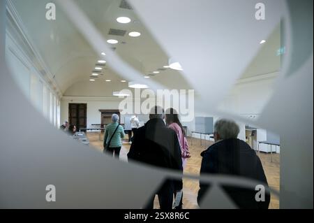 23 février 2025, Saxe-Anhalt, Sangerhausen : les gens attendent dans le «Golden Hall», où se trouve un bureau de vote de la ville de Sangerhausen, pour voter. L’élection anticipée au 21e Bundestag allemand a lieu dimanche. Photo : Heiko Rebsch/dpa Banque D'Images