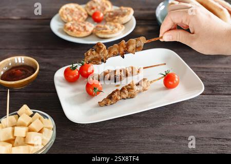 Brochettes de poulet juteuses avec glaçage teriyaki, servies sur une assiette blanche, une collation de bar ou un hors-d'œuvre Banque D'Images