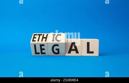 Symbole éthique et juridique. Cubes en bois tournés avec des mots éthiques et légaux. Beau fond bleu. Business et concept éthique et juridique. Copier sp Banque D'Images